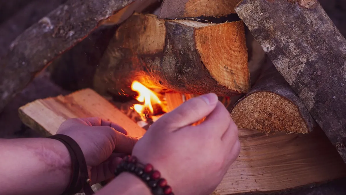 Ferro rod throwing sparks into a tinder bundle on wet ground