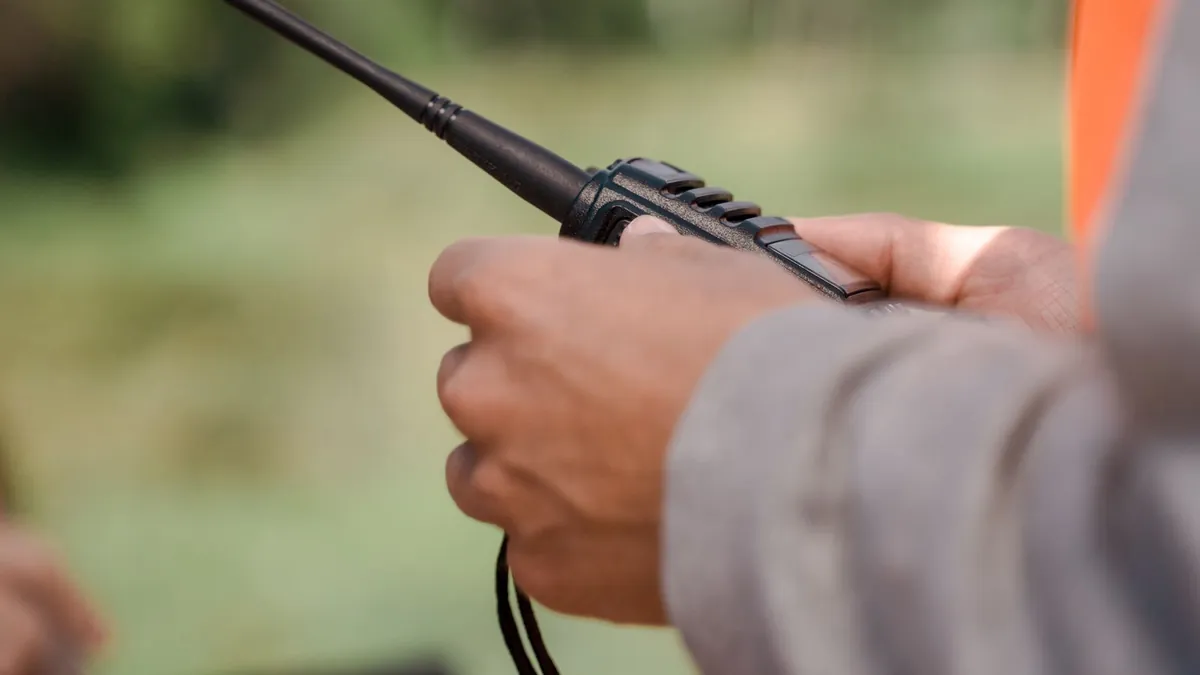 Two handheld GMRS radios and a mobile radio microphone on a truck seat