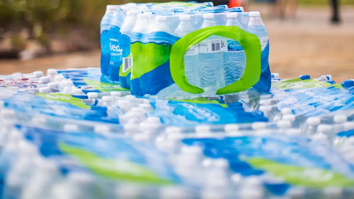 Stacked cases of bottled water outdoors, ready to hand out